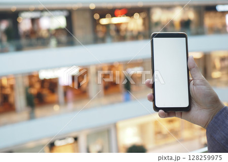 Capturing a moment with a smartphone in a shopping mall 128259975