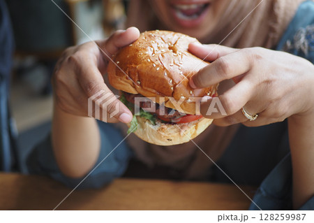 Enjoying a delicious burger at a casual dining spot 128259987
