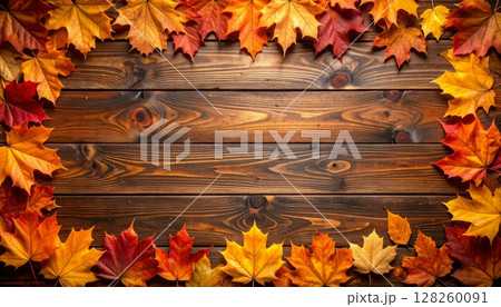 Golden autumn maple leaves create a vibrant, colorful border on a rustic wooden background, capturing the essence of the fall season 128260091