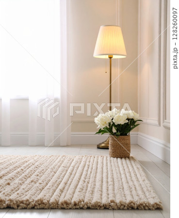 Modern living room interior with stylish furniture, a vase of flowers on the table, and warm lamp light illuminating the decor Modern living room interior with stylish furniture, a vase of flowers on the table, and warm lamp light illuminating the decor 128260097