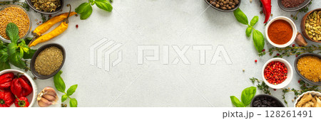 Colorful, fresh herbs and spices framing a gray background, a perfect natural border to bring attention to culinary creativity, top view and copy space, banner 128261491