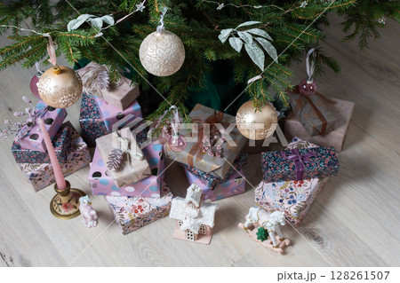 Vibrant pink and purple gift boxes with shiny ribbons rest under a Christmas tree adorned with glowing lights, creating a playful and joyful festive scene Vibrant pink and purple gift boxes with shiny ribbons rest under a Christmas tree adorned with glowing lights, creating a playful and joyful festive scene 128261507