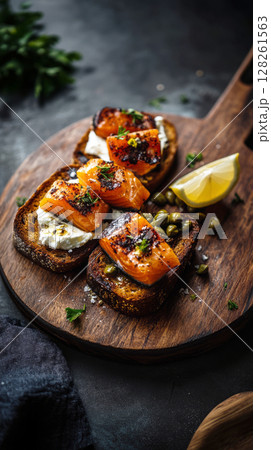 Creative toast showcases a flavorful combination of smoked salmon, creamy cheese, capers, and lemon garnished on rustic bread. Perfect for brunch or a stylish snack Creative toast showcases a flavorful combination of smoked salmon, creamy cheese, capers, and lemon garnished on rustic bread. Perfect for brunch or a stylish snack 128261563