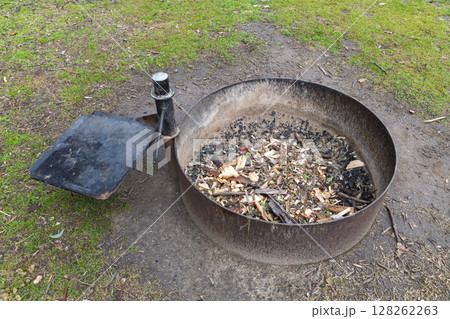 A steel ringed fire pit in a large family campground in the mountains A steel ringed fire pit in a large family campground in the mountains 128262263