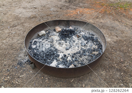 A steel ringed fire pit in a large family campground in the mountains 128262264