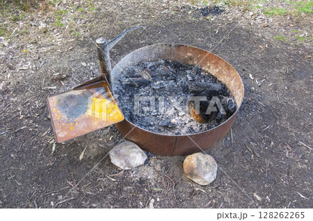 A steel ringed fire pit in a large family campground in the mountains A steel ringed fire pit in a large family campground in the mountains 128262265