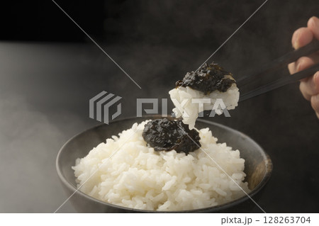 海苔の佃煮を乗せた炊きたてのご飯を箸で持ち上げる 128263704