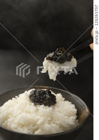 海苔の佃煮を乗せた炊きたてのご飯を箸で持ち上げる 128263707