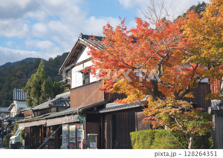 Traditional Japanese street with autumn foliage and rustic buildings. Kyoto, Japan 128264351