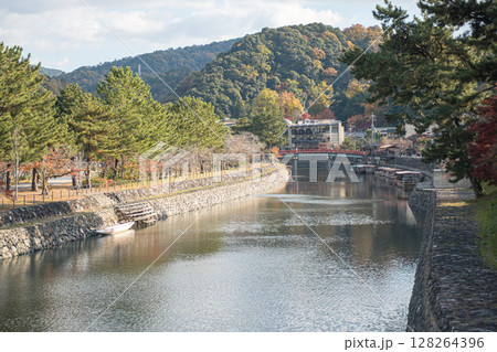Uji, Kyoto, Japan, Serene riverside scene with trees and distant mountains. 128264396