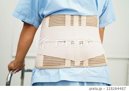 Asian woman wearing lumbar support pain back and use walker in hospital. 128264487