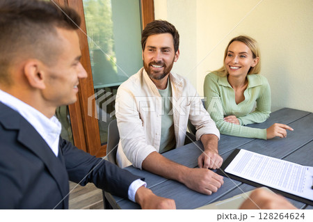 Real estate agent discussing deal with couple on laptop outside home Real estate agent discussing deal with couple on laptop outside home 128264624