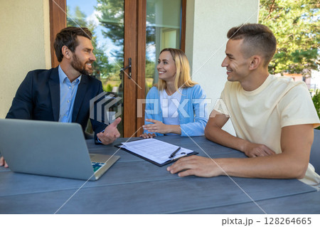 Real estate agent discussing deal details with the clients Real estate agent discussing deal details with the clients 128264665