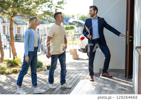 Male real estate agent presenting a new house to the clients 128264668