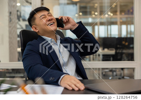 Young manager talking on the phone and feeling joyful and contented 128264756