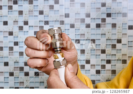 Compression ring is positioned by plumber on pipe section before tightening coupling that joins multilayer pipes in water supply system. Compression ring is positioned by plumber on pipe section before tightening coupling that joins multilayer pipes in water supply system. 128265987