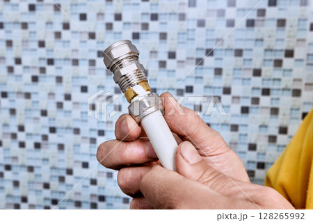 Tightening nut onto threaded coupling causes compression ring to press against multilayer pipe and secure fitting inside pipe for plumbing connection. 128265992