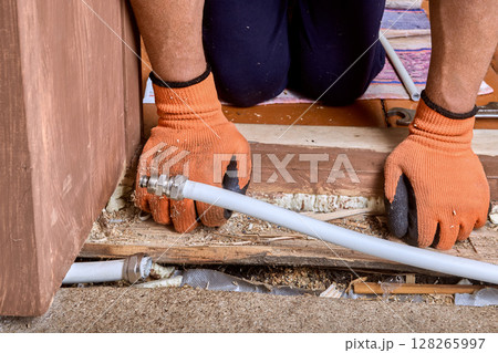 Plumber aligns multilayer pipe sections and installs compression coupling to repair water line damaged by freeze-induced crack during winter. 128265997