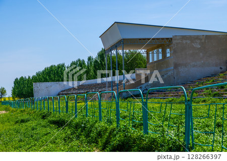 Overgrown wooden bleachers in Kok-Boru stadium in Kyrgyzstan Overgrown wooden bleachers in Kok-Boru stadium in Kyrgyzstan 128266397