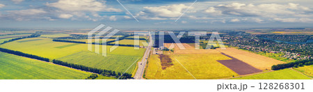 Sunny day in the countryside. Rural landscape in daylight. Aerial view of the countryside, country road, fields, and beautiful cloudy sky Sunny day in the countryside. Rural landscape in daylight. Aerial view of the countryside, country road, fields, and beautiful cloudy sky 128268301