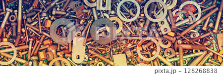 Abstract grunge colorful metal background made of fastening bolts, screws, and nuts. Horizontal banner 128268838