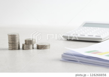 Coins and objects on a table with a financial and economic concept. Coins and objects on a table with a financial and economic concept. 128268856