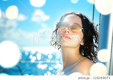 Woman enjoying sun on sailboat in ocean during summer vacation 128269073