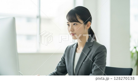 真剣にパソコンに向かって仕事に取り組む20代の若手女性社員 128270138