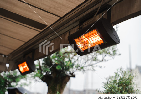 Two electric infrared patio heater glowing on a terrace in Bergen, Norway Two electric infrared patio heater glowing on a terrace in Bergen, Norway 128270250