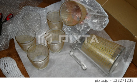 Packing up glassware into plastic bubble wrapping 128271239