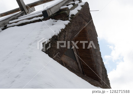 雪が積もっている茅葺き屋根 128271588