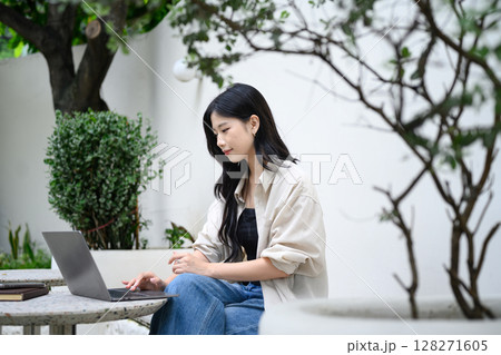Freelancer enjoying remote work at a quiet outdoor cafe with green plants and natural light Freelancer enjoying remote work at a quiet outdoor cafe with green plants and natural light 128271605