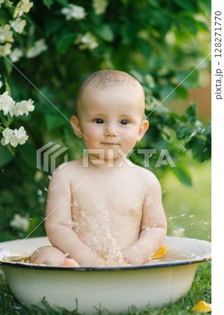 Baby Sitting In Bowl With Citrus And Water Outdoors 128271770