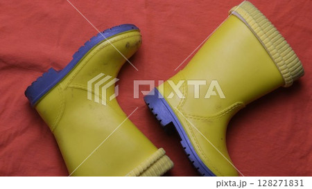 Dirty kids yellow rubber boots top view Dirty kids yellow rubber boots top view 128271831