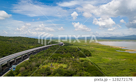 A wide aerial shot of Lam Takhong reservoir surrounded by hills and greenery in Nakhon Ratchasima. The scenic water source blends nature, infrastructure, and regional beauty 128272176