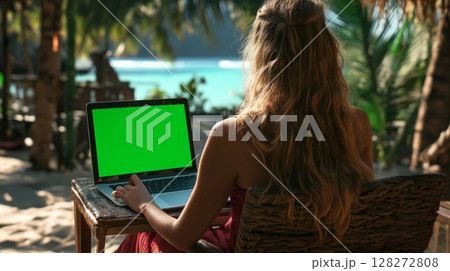 Person Working on Laptop Outdoors in Tropical Setting by the Beach During Sunny Day 128272808