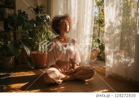 Meditation Session in a Sunlit Room Surrounded by Plants During the Morning Hours 128272810