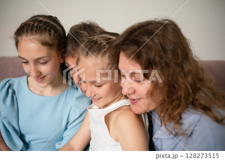 Family, Reading, Togetherness: Three generations bonding indoors by looking at something, sharing a cozy, lovely moment. Family, Reading, Togetherness: Three generations bonding indoors by looking at something, sharing a cozy, lovely moment. 128273515