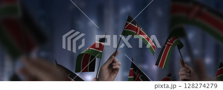 Kenya flags in their hands on a blurred urban background 128274279