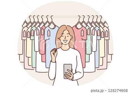 Woman with phone near hanger with T-shirts rejoices sale and opportunity to buy clothes at discounts Woman with phone near hanger with T-shirts rejoices sale and opportunity to buy clothes at discounts 128274608