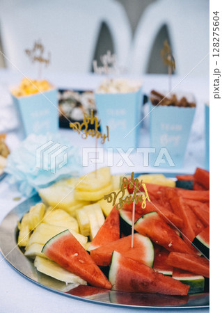 Colorful fruit platter with decorative picks at a festive gathering outdoors 128275604