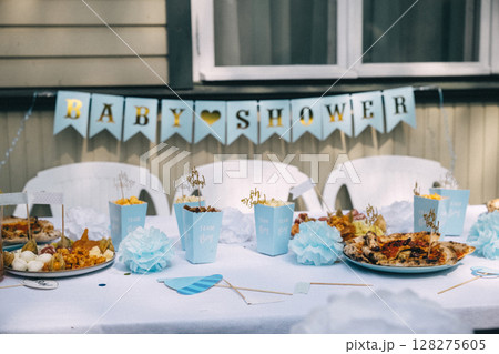 Festive baby shower celebration with decorative table and food display in a cozy setting Festive baby shower celebration with decorative table and food display in a cozy setting 128275605