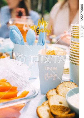 Sweet treats and savory snacks at a sunny baby shower gathering Sweet treats and savory snacks at a sunny baby shower gathering 128275606