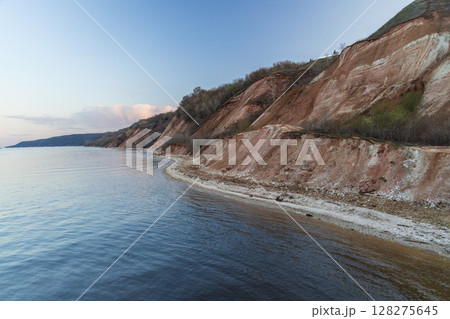 Rocky, pebble and clayey banks of the Kama River. Mountain slope of various rock types. Rocky, pebble and clayey banks of the Kama River. Mountain slope of various rock types. 128275645