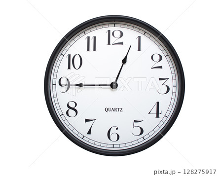 Round analog wall clock with a black frame, white face, and bold black numerals. showing  00:45 or 12:45. Isolated on a white background. Ideal for time-related themes. 128275917