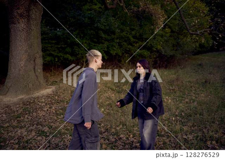 two 15-year-old teenagers in love play, hug , spend time together in an autumn park 128276529