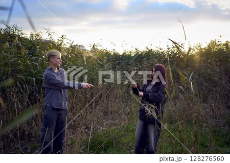 15-year-old teenage couple in love playing in reeds at sunset 15-year-old teenage couple in love playing in reeds at sunset 128276560