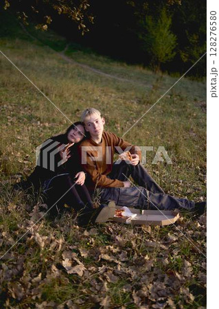 15-year-old teenage couple in love eating pizza on a picnic in an autumn park 128276580