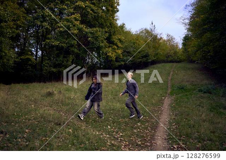two 15-year-old teenagers in love play, hug, spend time together in an autumn park two 15-year-old teenagers in love play, hug, spend time together in an autumn park 128276599