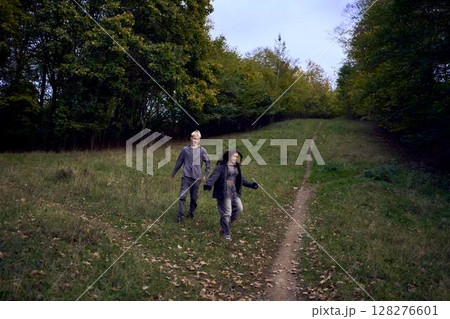 two 15-year-old teenagers in love play, hug, spend time together in an autumn park 128276601